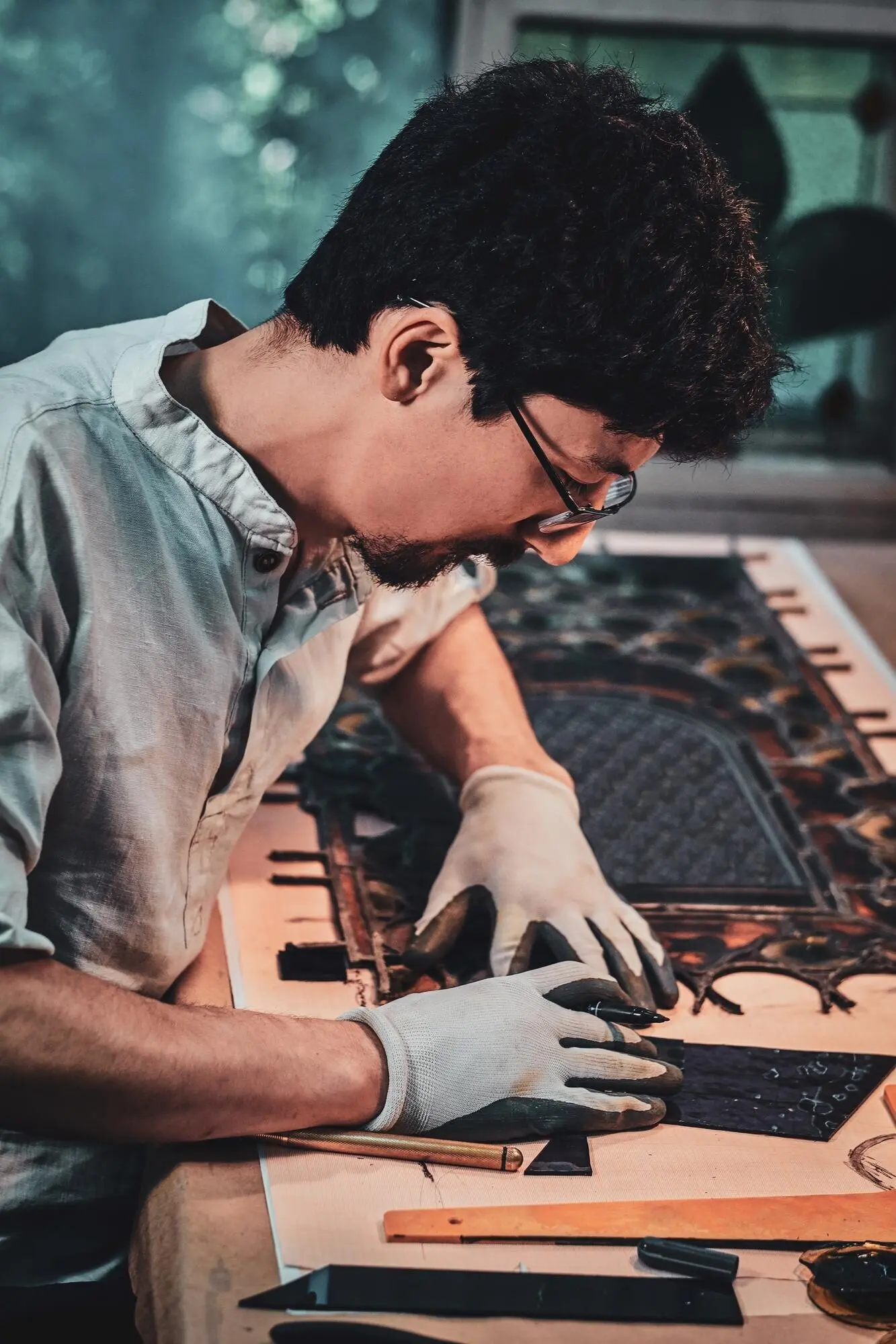 Ein fleißiger Restaurator mit Brille zählt in seiner eigenen Werkstatt die richtige Menge für Buntglas.